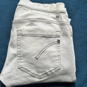 Ljusgrå jeans från Dondup - Snygga ljusgråa jeans från Dondup med knappar i gylfen och klassiska femficksdesign. Perfekta för en stilren look. De har en modern passform och är tillverkade i ett bekvämt material. Köpta förra sommaren så i princip nya. Tveka inte på att höra av er vid fler frågor🙌