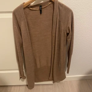 Beige kofta från Frame - Säljer en stilren beige kofta från Frame. Den har långa ärmar och knappar framtill. Perfekt för lager-på-lager under kyligare dagar. Passar bra till både jeans och kjol.