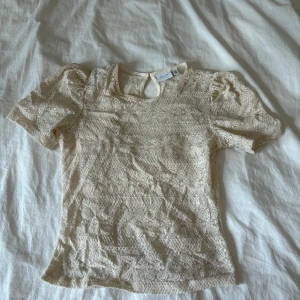 Beige spetsblus från Vila - Säljer en elegant beige spetsblus från Vila med korta puffärmar. Kommer inte till användning längre, därför jag säljer.