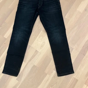 Mörkblå jeans från Jack & Jones - Snygga mörkblå jeans från Jack & Jones med en klassisk femficksdesign. De har en normal passform och är perfekta för en avslappnad stil. Märkeslappen i läder på baksidan ger en extra touch av stil.