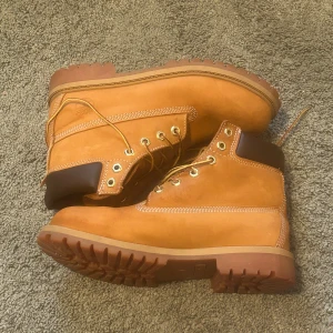 Bruna boots från Timberland - Säljer ett par klassiska bruna boots från Timberland med snörning och robust sula. Perfekta för höst och vinter med sin slitstarka design och bekväma passform.