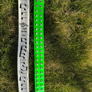 Två bälten med unika mönster - Säljer två coola bälten. Ett grönt bälte med silvernitar och ett vitt bälte med musiknoter. Perfekta för att ge din outfit en unik touch. Båda har silverfärgade spännen. Ett för 50 eller båda för 80! Tar även emot prisförslag! 