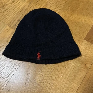Marinblå Ralph Lauren mössa - Säljer min ralphlauren mössa då den inte längre kommer till användning. Den är i bra skick!