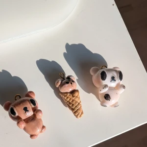 Handgjorda björnberlocker - Säljer tre unika handgjorda berlocker i form av björnar. En är brun, en är vit med svarta fläckar och en är en björn i en glasstrut. Perfekta som söta accessoarer till väskor eller nyckelringar. Som den sista bilden visar kan ni se att den bruna björnen inte ser så "sleek" ut eftersom jag prövade att måla men det gick åt skogen men det märks bara om man stirrar extremt mycket. Vit björn - 69 kr, Glass björn - 54 kr, Brun björn 59 kr. Allt kostar 150.