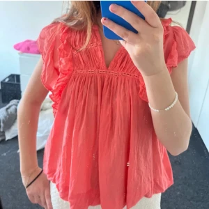 Neo noir blus - Supersöt korallrosa blus med volangdetaljer från Neo noir. I strl 42 men passar mig superbra som har xs-s, då storlekarna är väldigt lika varandra. Så fin färg på sommaren, köptes för 599