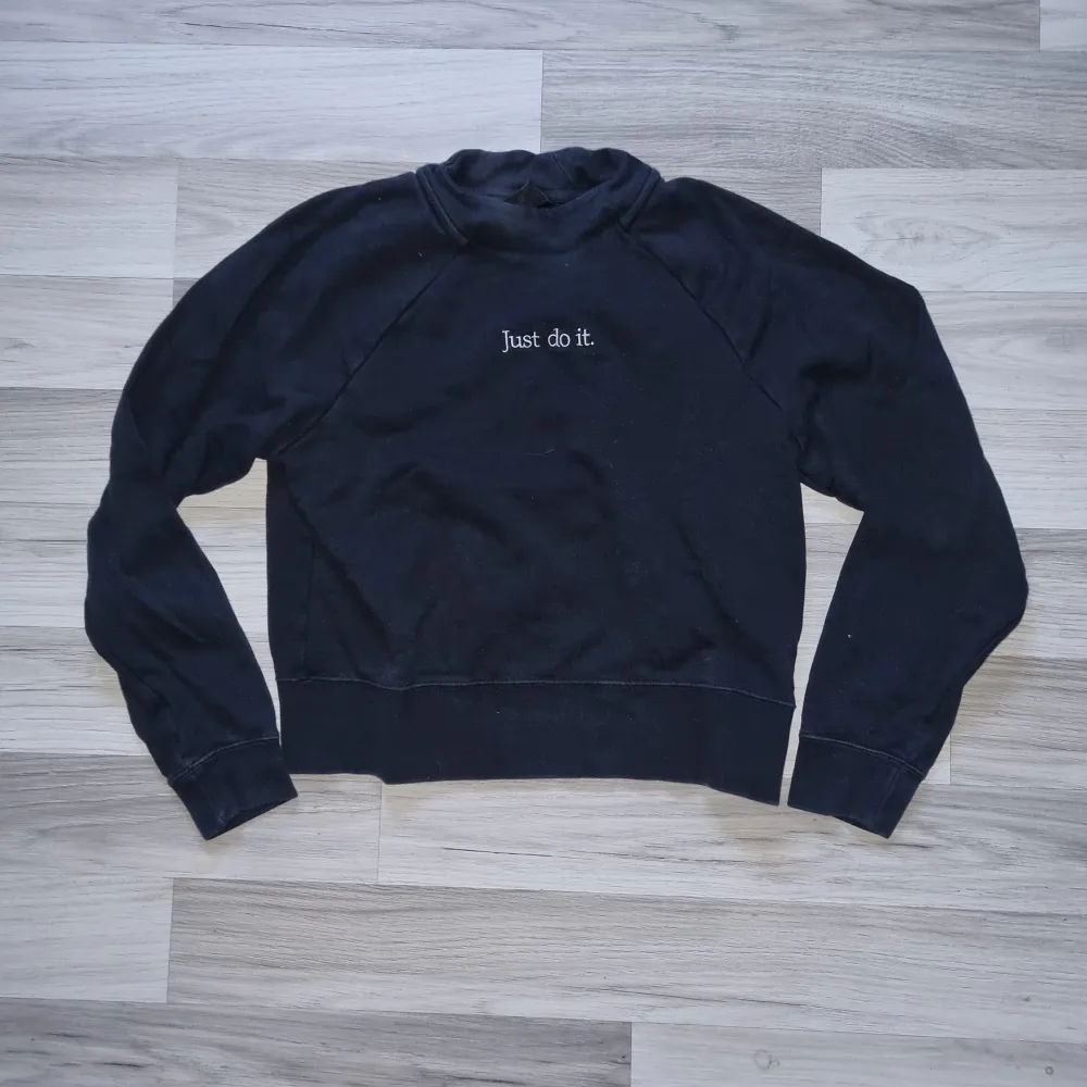 Säljer en svart sweatshirt från Nike med texten 'Just do it' broderad på framsidan. Tröjan har långa ärmar och en klassisk rund halsringning. Perfekt för en avslappnad stil eller träning.. Neuletakit & Villapaidat.