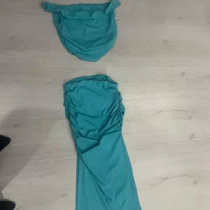 Turkos bikini med rynkdetaljer - Snygg turkos bikini med rynkdetaljer på både över- och underdel. Perfekt för en dag på stranden eller vid poolen. Den har en modern och stilren design som verkligen sticker ut.