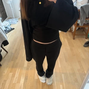 Svarta kostymbyxor - Snygga svarta lågmidjade kostymbyxor. Med snygg knäppning nertill