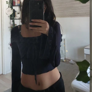 Långärmad tröja 🪩 - Säljer en elegant svart blus med långa ärmar och knytning framtill. Perfekt för en stilren look. Str XS. Skriv för mer info ❤️
