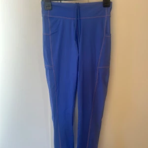 Blå leggings med fickor från energetics - Snygga blå leggings med praktiska fickor på sidorna. Perfekta för träning eller en aktiv vardag. De har en hög midja och är tillverkade i ett stretchigt syntetmaterial för bästa komfort och passform.