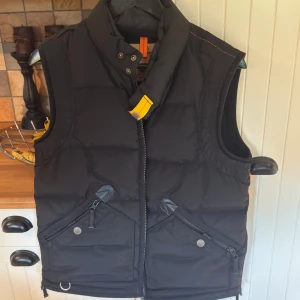 Parajumpers kobuk  - Säljer en äkta Parajumpers Kobuk-väst i färgen färg, svart storlek M. Västen är i mycket fint skick, sparsamt använd och fri från skador, fläckar och lukt.