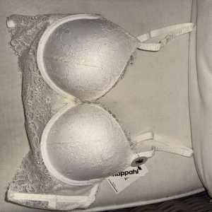 Vit spets-bh 80A - Supersnygg vit bh från Kappahl med  spetsdetalj över hela kuporna och sidorna. Push up modell, storlek 80A - aldrig använd utan ny med prislapp. Kan gå ner i pris vid snabb affär❤️ Bundle rabatt finns!❤️