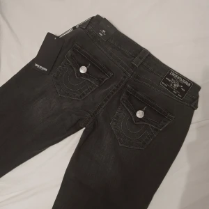 Nya Bootcut jeans från True Religion - Helt nya oanvända med prislappen kvar. Säljer för de är för små. Modellen är Joey Low Rise Flare och storlek 25. Färg Charcole. Midjemått 36cm innerbenslängd 80cm!