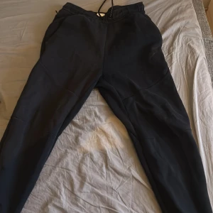 Nike tech byxor - Säljer mina nike tech byxor för de inte kommer till någon användning längre, de är rätt så använda och det är nått litet hål men inget som syns eller känns, skick 7/10