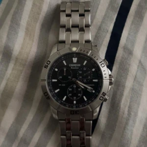 Champion Roadster silverfärgad klocka - Snygg och robust klocka från Champion Roadster med svart urtavla och flera små urtavlor. Klockan har en silverfärgad länk i metall och tydliga siffror på boetten. Perfekt accessoar för dig som gillar sportig och stilren design.