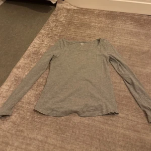 Grå långärmad tröja från 157 - Enkel och stilren grå långärmad tröja från 157. Tröjan har rund halsringning och är tillverkad i mjuk bomullsmix, perfekt för lager-på-lager eller chill dagar. Passformen är normal och materialet är tunt och skönt mot huden.