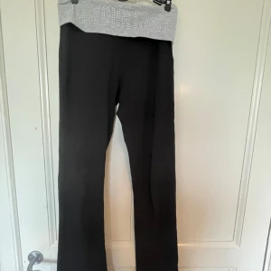 Svarta yoga pants med grå kant - Ett par svarta yoga pants med grå kant och med glittriga stenar!! Så snygga 