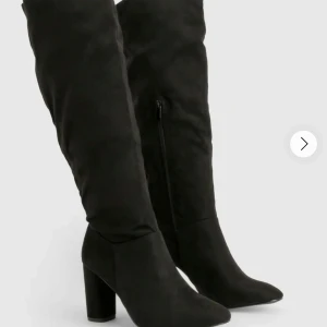 Svarta knähöga boots💞 - Snygga svarta stövlar i mocka-look med hög klack och spetsig tå. Stövlarna går upp till knäet och har dragkedja på insidan för enkel påtagning. Perfekta för att lyfta din outfit med en trendig och stilren vibe. Köpta från Boohoo för 840kr och endast använda två gånger!! 