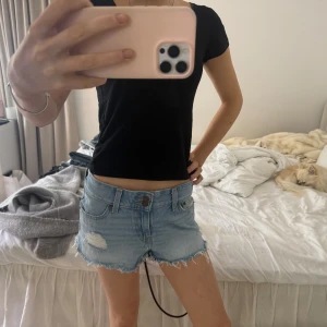 Lågmidjade ljusblå jeansshorts från LEVI’s - Ljusblå jeansshort ifrån LEVI’S. Storlek 26 i modell ”Superlow shorts”. 