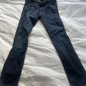 Mörkblå Slim Glenn jeans från Jack & Jones - Säljer ett par mörkblå Slim Glenn jeans från Jack & Jones med superstretch. Modellen har smal passform, klassisk femficksdesign och kontrastsömmar. Perfekta om du gillar jeans som sitter tajt men ändå är bekväma.