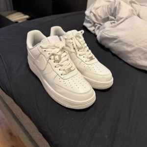 Vita Nike Air Force 1 sneakers - Säljer ett par klassiska vita Nike Air Force 1. Ligger mest och samlar dam då jag inte är så mycket för vita skor. Skriv till mig för mer bilder och info. 