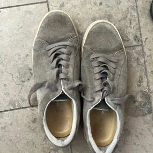 Grå vagabond - Snygga grå sneakers i mocka från vagabond med platt sula och rund tå. Skorna har matchande grå snörning och en vit kant runt sulan. Perfekta för en avslappnad och stilren look.
