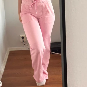 Rosa mjukisbyxor med snörning XS - Säljer ett par ljusrosa mjukisbyxor från 157 i storlek XS. Byxorna har hög midja med bred resår och snörning, raka ben och stora fickor både fram och bak. Tillverkade i mjuk bomull, perfekta för chill dagar.