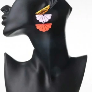 Färgglada solfjäder statement örhängen i lätt akryl - Nya & oanvända  -  Färgglada och lekfulla örhängen i solfjäderform – perfekta till festival, sommarfest eller när du vill lyfta en enkel outfit. Tillverkade i speglande akryl i guld, lila och rött, med stift i rostfritt stål. Lätta att bära (endast 6 g). Mått: ca 5,2 cm långa och 3,3 cm breda. Helt nya och oanvända. Priset är redan lågt – jag prutar inte, men erbjuder bra rabatt vid köp av flera saker. Jag rensar smyckesskrin och garderob, så kika gärna på mina andra annonser också. 