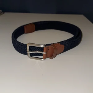 Mörkblå grish bälte  - Snyggt mörkblått grish bälte från Jack & jones, riktigt snyggt bälte till dig som vill ha en fräsch o lyxig still! 