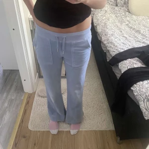 Ljusblå mjukisbyxor Juicy Couture XXS - Säljer ett par ljusblå mjukisbyxor från Juicy Couture i storlek XXS. Byxorna har snörning i midjan, fickor fram och bakfickor med knappar. Materialet är mjukt och stretchigt, 95% polyester och 5% elastan. Passformen är flare med utsvängda, passar 1,60 cm. Använda ett antal gånger men mycket bra skick för dem har inga skavanker. Säljer pga för korta i benen