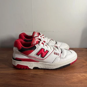 Nike New Balance 550  - Säljer ett schyssta New Balance 550 sneakers i vitt med röda och svarta detaljer. Skorna är i väldigt bra skick och passar perfekt nu till sommaren/hösten