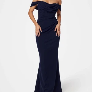 Marinblå långklänning offshoulder - Säljer en elegant marinblå långklänning med offshoulder. Klänningen har figurnära passform och svepande kjol som ger en snygg siluett. Perfekt för bal eller fest, med stilren design och mjukt material som sitter bekvämt hela kvällen.