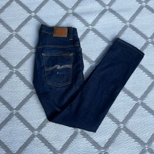 Nudie Jeans - Asfeta mörkblå jeans från Nudie 🔥 Storleken är W32 L32, men sitter mindre. Skicket 7/10 där knappens hål är lite slitet ‼️Ett hål på benet också. Modell är Thin fin 🙏 Smuts försvinner i tvätten. Nypris 1599 👀 Hör av er vid frågor eller funderingar 🙏