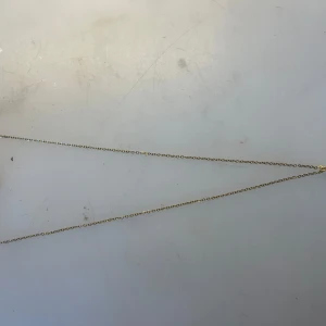 Guldhalsband med vit pärla - Ett stilrent halsband med tunn guldfärgad kedja och en rund vit pärla som hänge. Perfekt för dig som gillar minimalistiska smycken med en elegant touch. Kedjan är enkel och diskret, medan pärlan ger en klassisk känsla. I rostfritt stål och handgjort 