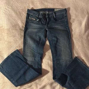 Vintage Diesel lågmidjade bootcut jeans - Snygga vintage lågmidjade bootcut jeans från Diesel! Jeansen har lätt slitna detaljer framtill och en cool tvätt! W27/L30