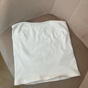 Vit ribbad topp från Gina Triooo  - Enkel och stilren vit ribbad topp från Gina Tricot. Toppen har en tight passform och är gjord i mjuk bomull med stretch. Perfekt att matcha med låga byxor eller mjukis för en chill look.