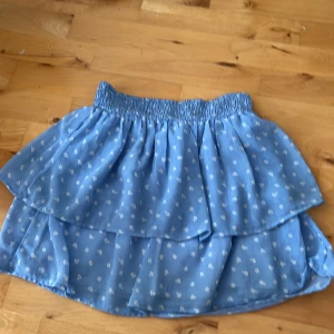 Blå kjol - Säljer en blå kortkjol med blommor! Kontakta om det är något!🫶🏻