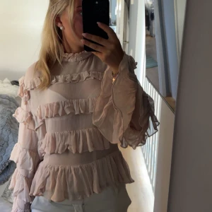 Volangblus - Säljer denna skit snygga rosa volangblusen från HM, den är i mesh tyg och har lite vida armar