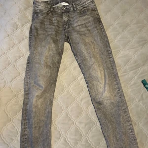 Slim grå jeansbyxor W32 L30 - Slim fit jeansbyxor från Vailent i en snygg grå tvätt med klassisk femficksdesign. Byxorna har raka ben och normal midja, med detaljer som dragkedja och knapp framtill. Perfekta för dig som gillar en stilren och modern look.