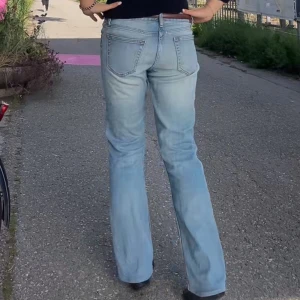 Bootcut ljusblå jeans - Säljer ett par ljusblå bootcut jeans. Jeansen har en lätt tvättad look och är tillverkade i mjukt denimtyg. Passformen är loose och midjan är midwaist, perfekt för en chill och avslappnad stil.