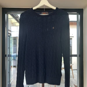 Mörkblå stickad tröja Morris - Snygg mörkblå stickad tröja från Morris. Perfekt tröja nu till hösten. Tröjan är i storlek M men vart tvättat fel engång så den passar mer S