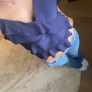 Mörkblå volangig linnetopp från Shein - Säljer en mörkblå linnetopp från Shein i storlek M. Toppen har smala axelband, v-ringning och flera lager med volanger som ger en snygg och lekfull look. 