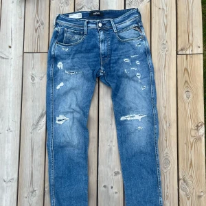 Blå Replay Anbass med slitningar  - Säljer nu dessa extremt eftertraktade replay anbass jeans. Byxorna är i mycket bra skick och helt defektfri. Kontakta vid minsta fråga! W31 L32