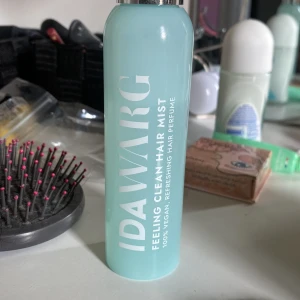 IDA WARG Feeling Clean Hair Mist - Fräsch hårparfym från IDA WARG i en ljusblå cylinderformad flaska med silvrig kork. 100% vegansk och ger en uppfriskande känsla till håret. Perfekt för att boosta doften och fräschheten under dagen.