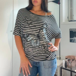 Y2k tshirt - Snygg randig y2k tshirt med fjärilar! Köpt second hand men är i jättefint skick.