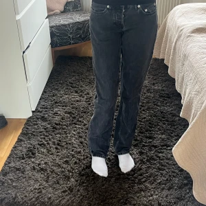 Svarta straight jeans från 157, XXS - Säljer ett par svarta jeans från 157 i modellen Icon, storlek XXS. Jeansen har klassisk femficksdesign, raka ben och normal passform. Materialet är jeans med snygg mörk tvätt och silverfärgade knappar. Perfekt för dig som gillar enkel och stilren look.