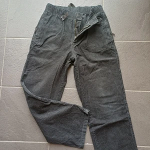 Svarta manchesterbyxor från H&M - Svarta manchesterbyxor från H&M i relaxed fit med elastisk midja och justerbart spänne framtill. Byxorna har raka ben och diskreta fickor både fram och bak. Perfekta för en chill och stilren look.