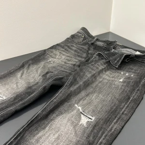 Svarta jeans med slitningar från Jack and Jones  - Snygga svarta jeans från Jack and Jones med en cool tvättad look. Väldigt bra skick då jag inte använt de så mycke