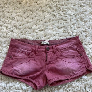 Rosa jeansshorts från Xdye - Snygga rosa jeansshorts från Xdye med låg midja och coola nitar på fickorna. Storlek 36. Använda Max 3 gånger.