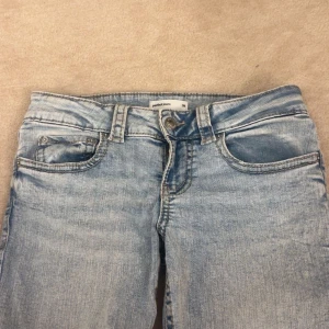 Ljusblå jeans  - Snygga ljusblå jeans från Gina Tricot med bakfickor som har lock och knapp. Jeansen är low waist bootcut och sitter jätte bra! Perfekta för en avslappnad och trendig look.